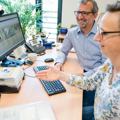 Bild vergrößern: Zwei Personen arbeiten gemeinsam am PC
